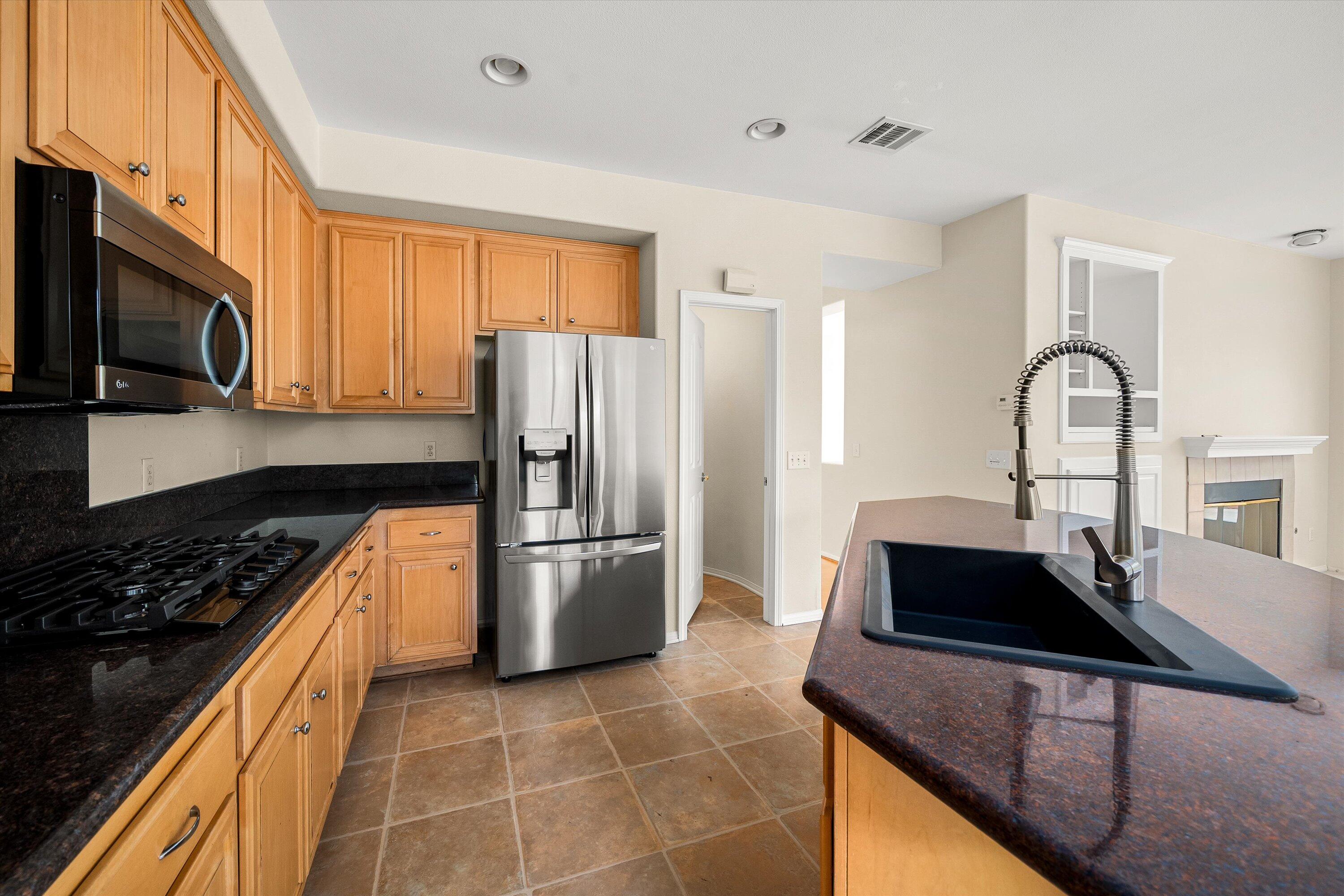 458 Greenleaf Court Goleta, CA 93117 - Photo 8 of 34 a kitchen with granite countertop a refrigerator and a stove top oven