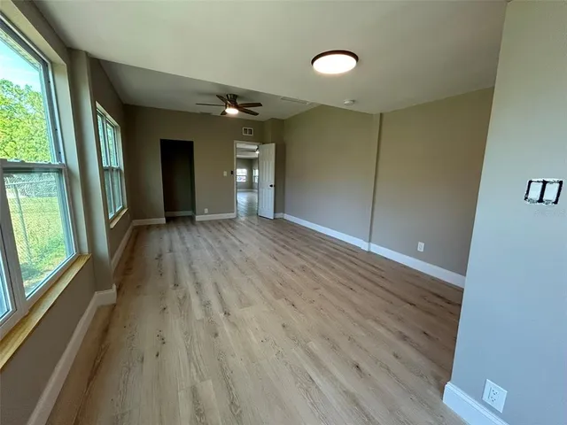 a view of hallway with a large window and wooden floor