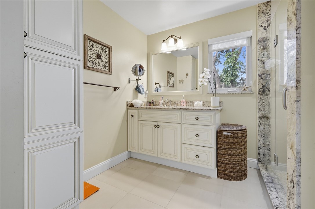 902 Tides Road Vero Beach, FL 32963 - Photo 15 of 25 a bathroom with a granite countertop sink a vanity and a window