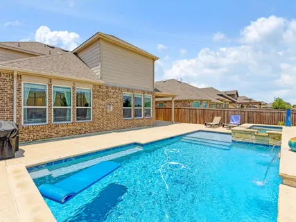 a view of a house with pool and a yard
