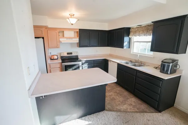 a kitchen with a sink stove and refrigerator
