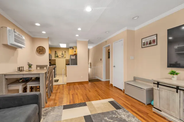 a open kitchen with stainless steel appliances granite countertop a refrigerator a stove and a sink with wooden floor