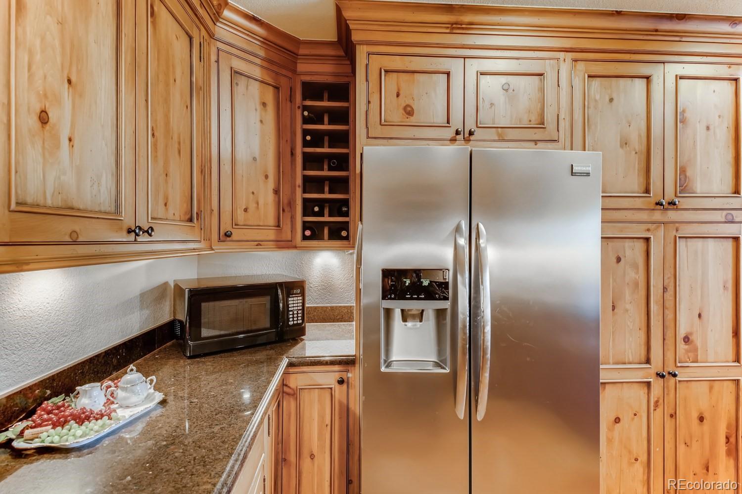 869 Hill And Dale Road, Unit D Golden, CO 80401 - Photo 12 of 27 a kitchen with granite countertop a refrigerator and cabinets