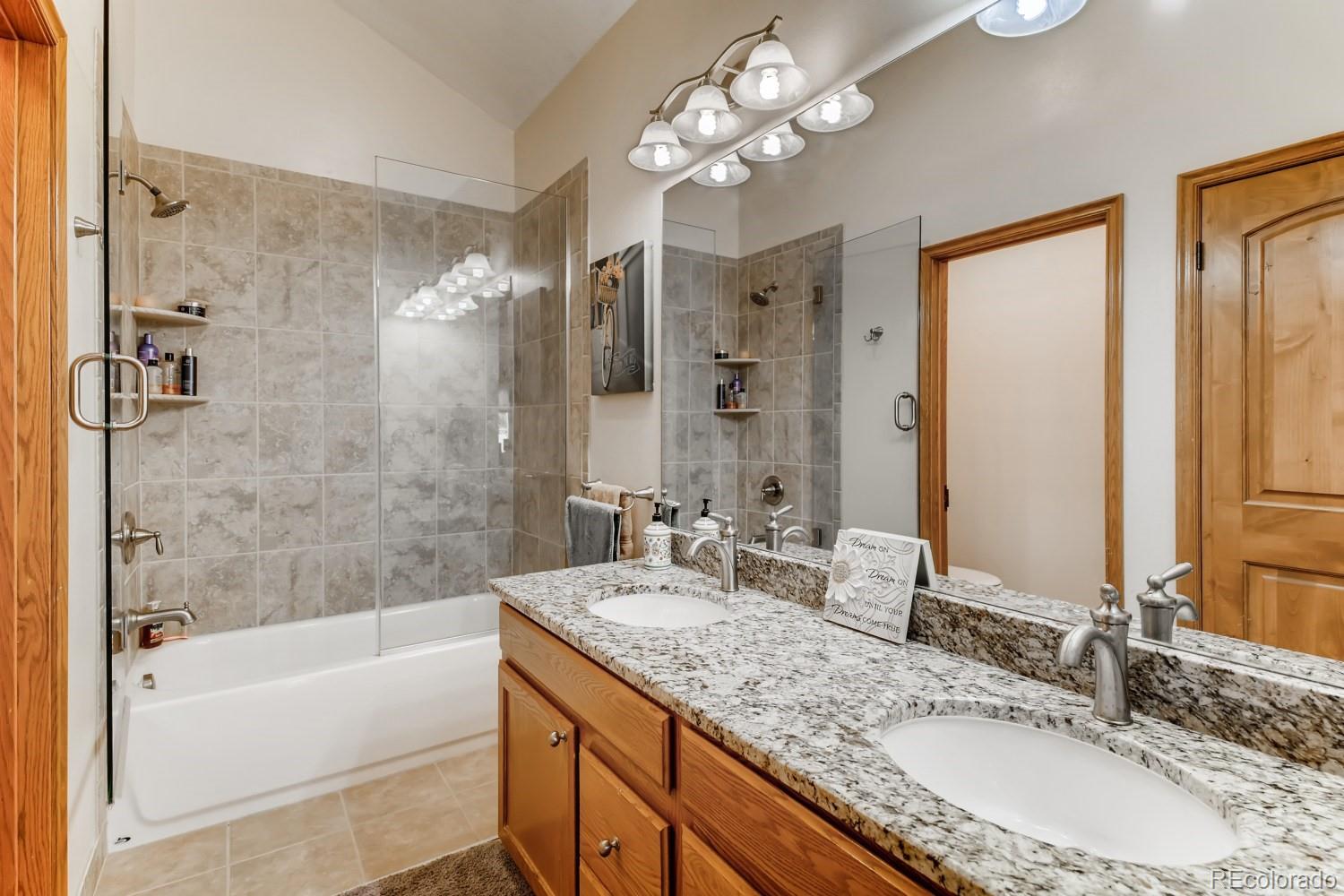 869 Hill And Dale Road, Unit D Golden, CO 80401 - Photo 19 of 27 a bathroom with a granite countertop sink a large mirror and a bathtub