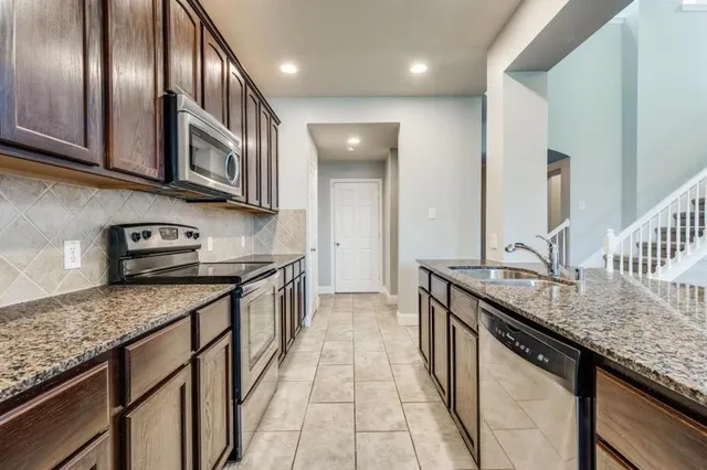 a kitchen with stainless steel appliances granite countertop granite countertop a sink stove and cabinets