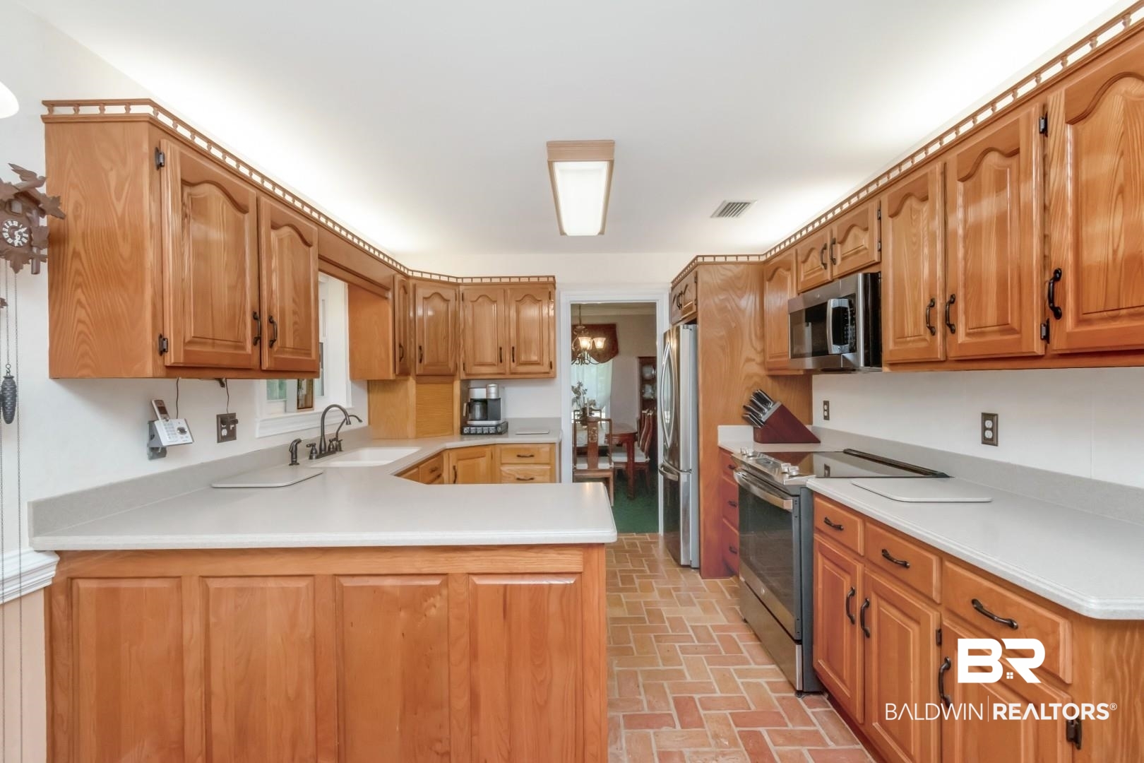 8220 Fordham Road Mobile, AL 36619 - Photo 6 of 41 Kitchen featuring a sink, a peninsula, visible vents, light countertops, and appliances with stainless steel finishes