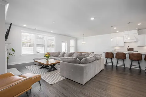 a living room with furniture and a wooden floor