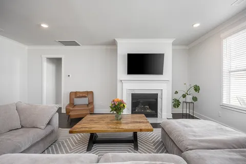 a living room with furniture a fireplace and a flat screen tv