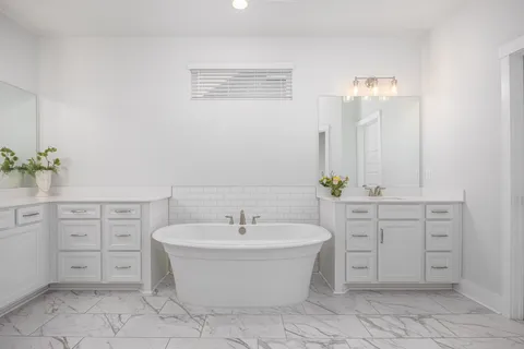 a bathroom with a bathtub sink shower and mirror