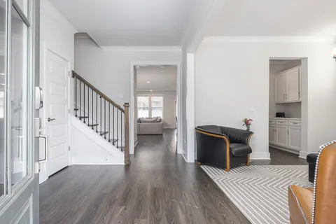 a view of a livingroom with wooden floor and furniture