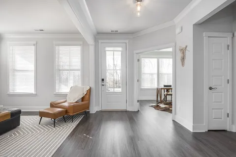 a living room with furniture a large window and a wooden floor