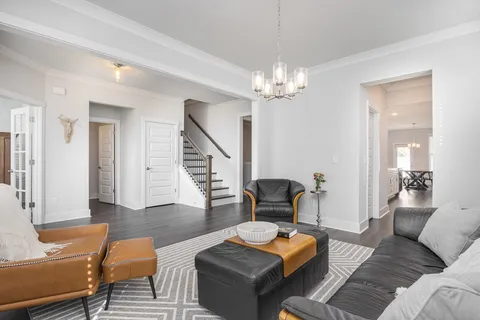 a living room with furniture and a chandelier