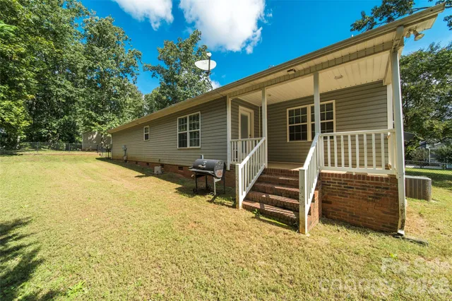a view of house with backyard and wooden fence