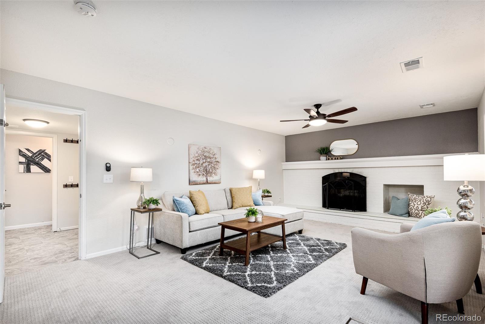 13492 Jackson Drive Thornton, CO 80241 - Photo 18 of 25 a living room with furniture a fireplace and a flat screen tv