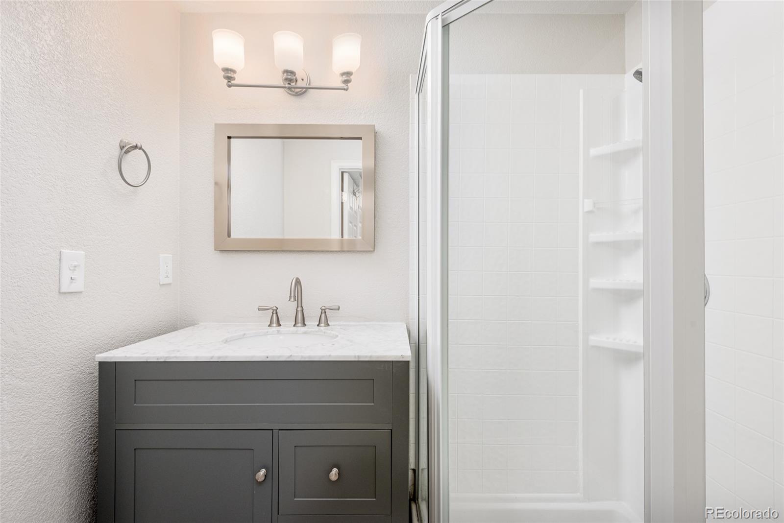 13492 Jackson Drive Thornton, CO 80241 - Photo 23 of 25 a bathroom with a sink vanity and a mirror