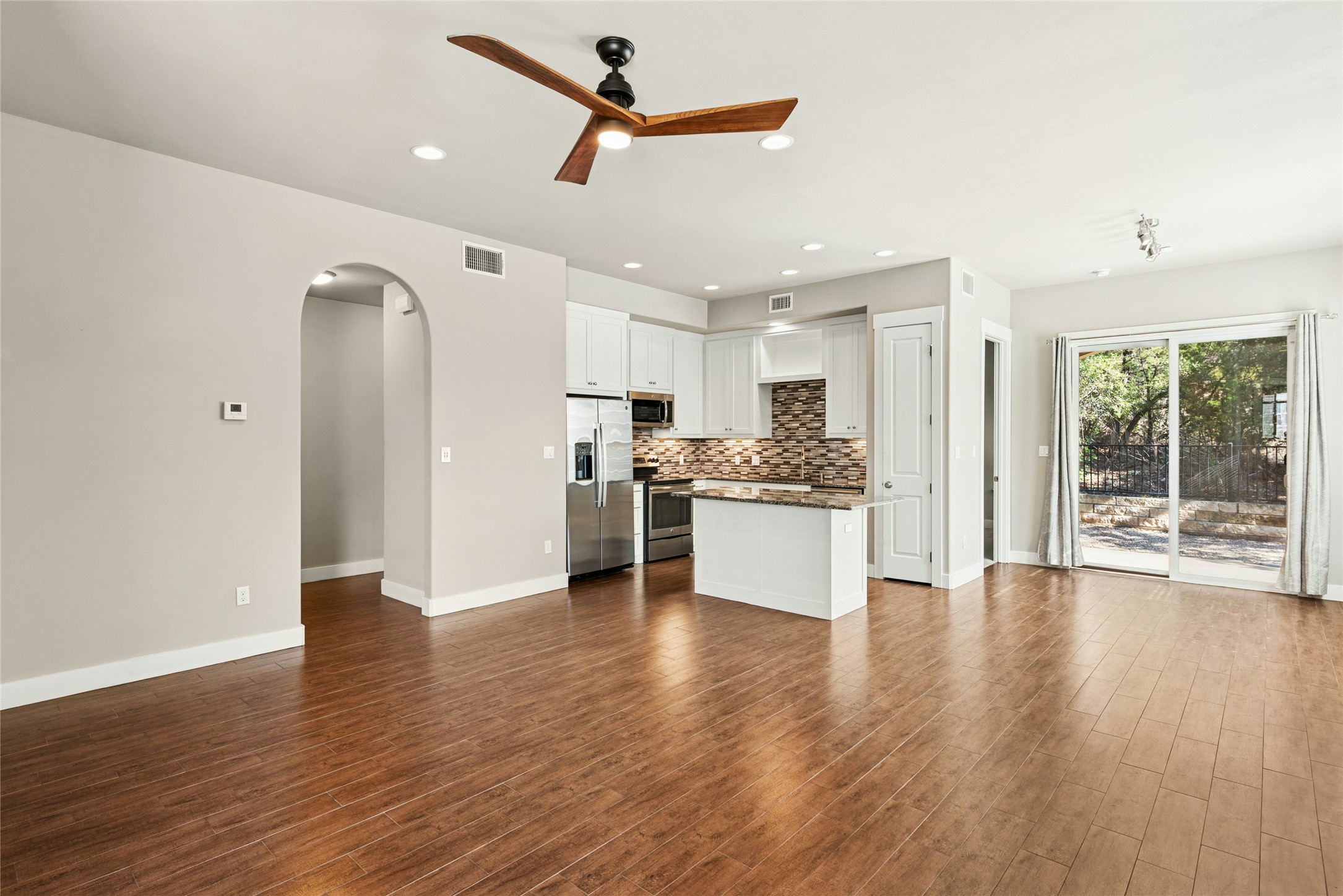 4301 Mansfield Dam Road, Unit 2101 Austin, TX 78734 - Photo 5 of 17 Unfurnished living room with ceiling fan, arched walkways, dark wood-type flooring, and recessed lighting