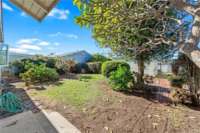 a view of a house with a yard and potted plants
