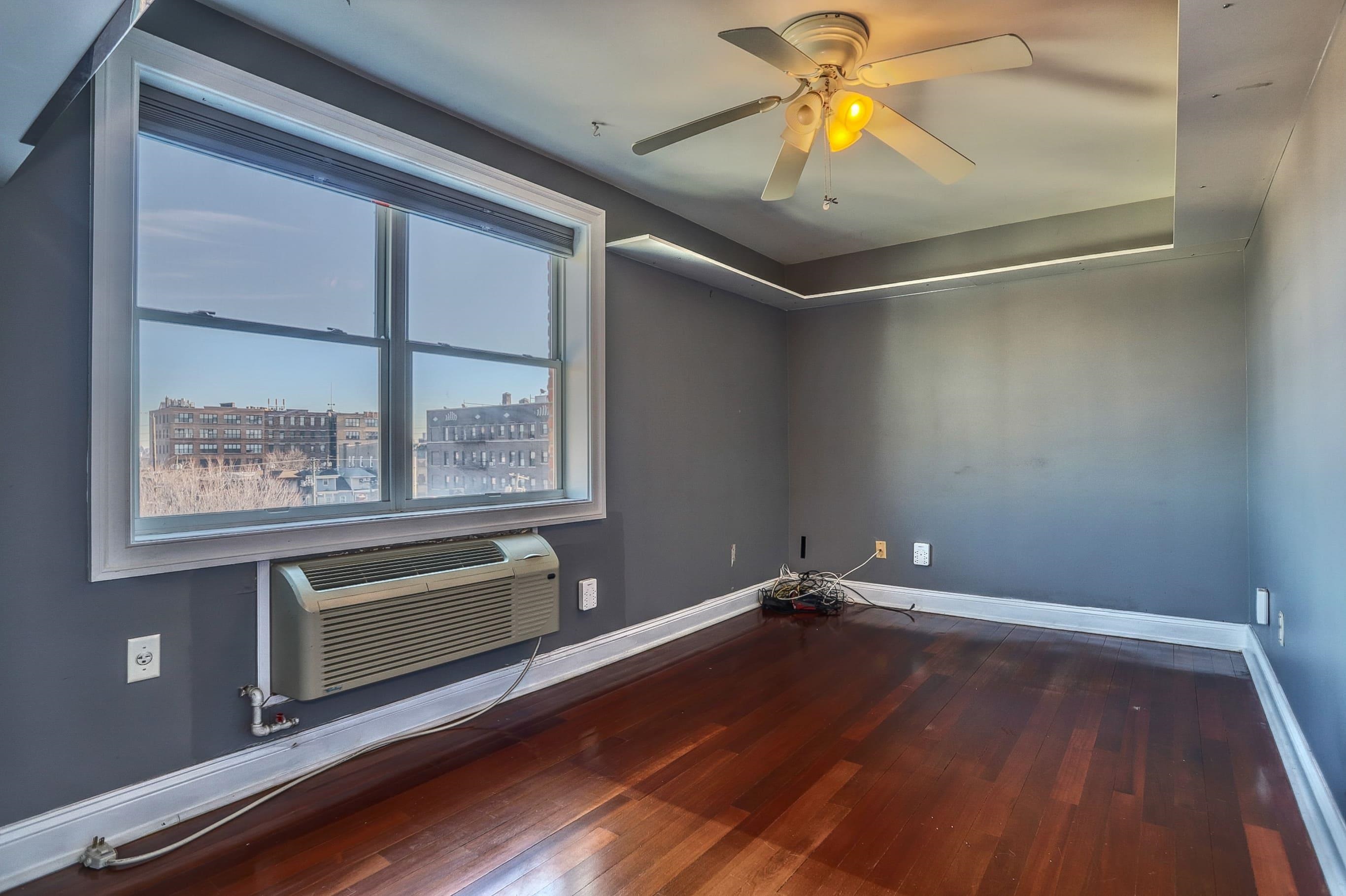 1720 New York Avenue, Unit 406 Union City, NJ 07087 - Photo 14 of 21 a room with wooden floor and window