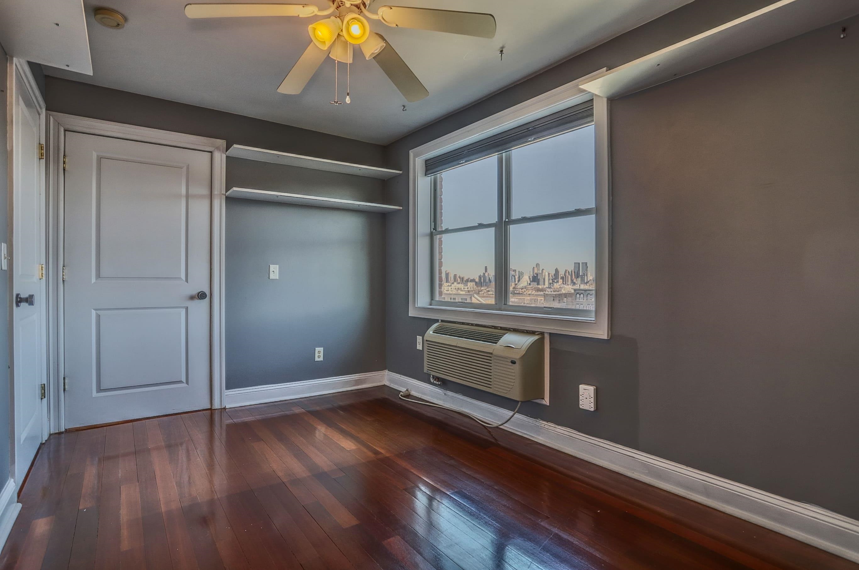 1720 New York Avenue, Unit 406 Union City, NJ 07087 - Photo 15 of 21 a view of an empty room with a window and wooden floor