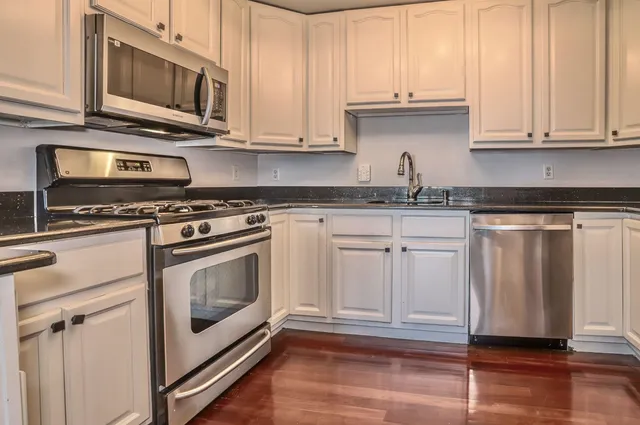 a kitchen with stainless steel appliances granite countertop a stove a microwave and cabinets