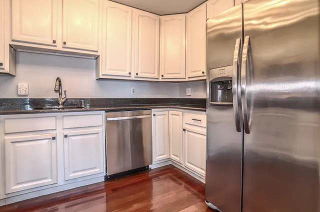 a kitchen with stainless steel appliances granite countertop a sink and a refrigerator