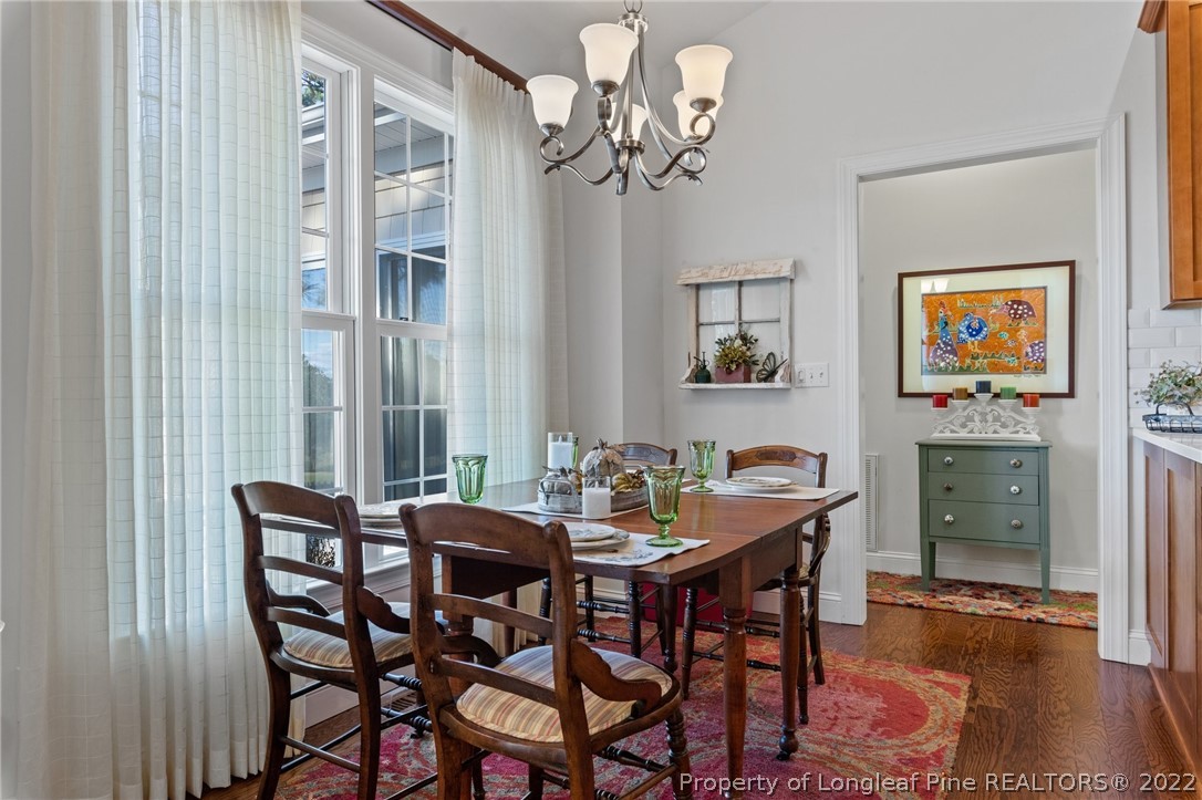1570 Valley View Road Southern Pines, NC 28387 - Photo 21 of 44 a view of a dining room with furniture wooden floor and a chandelier