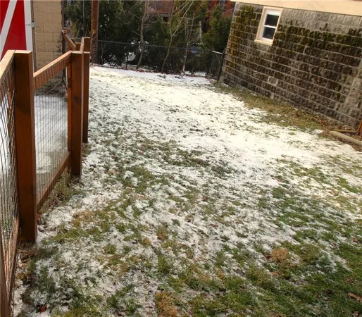 a view of a yard with wooden fence