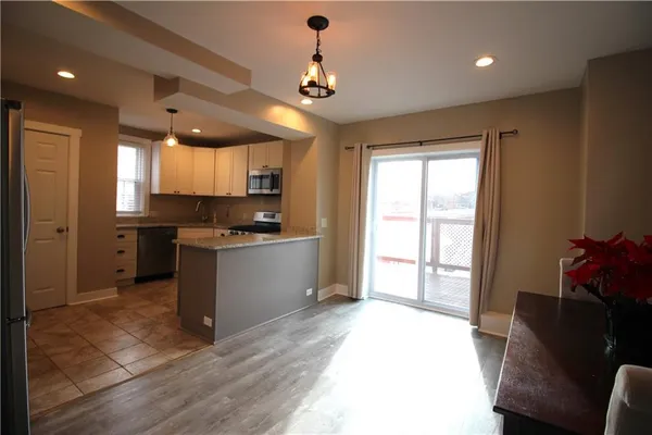a kitchen with granite countertop a stove a sink and a refrigerator