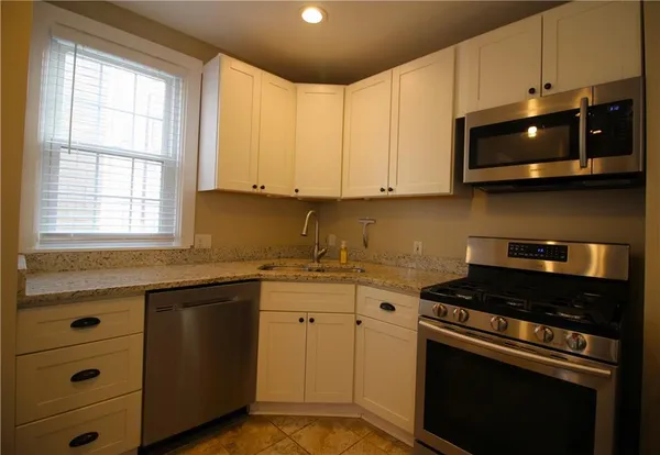 a kitchen with stainless steel appliances granite countertop a sink and a stove