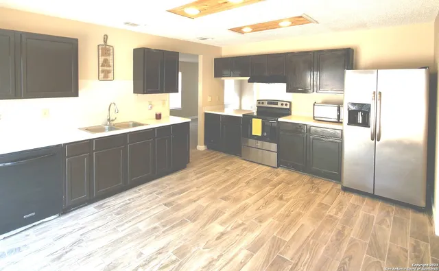 a kitchen with stainless steel appliances a refrigerator sink and microwave