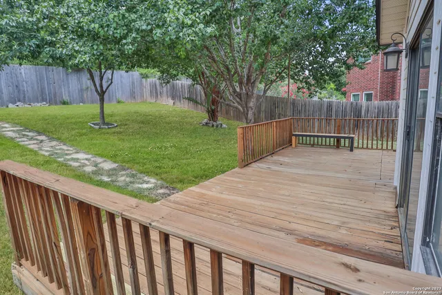 a backyard with wooden fence and a large tree