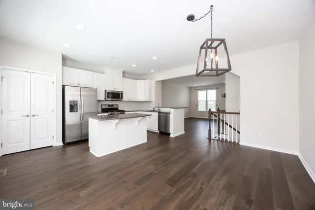 a view of kitchen with refrigerator and wooden floor