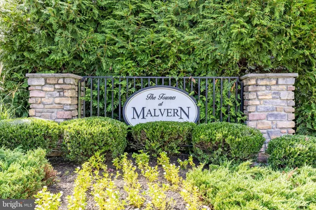 a sign that is sitting in front of flowers