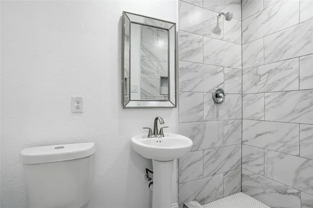 a bathroom with a sink a toilet and mirror