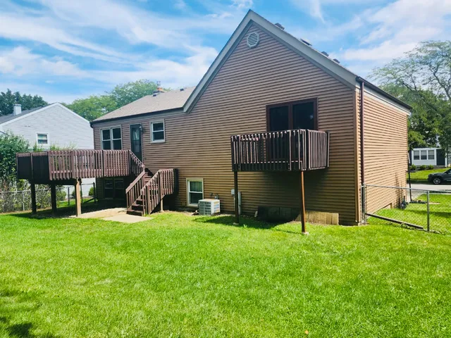 a view of a house with backyard and a tree