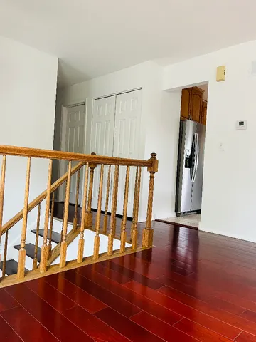 a view of staircase with lots of frames on wall and wooden floor