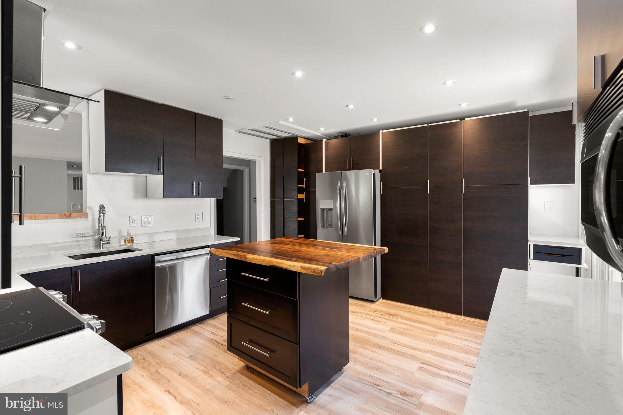 943 Willowleaf Way Potomac, MD 20854 - Photo 15 of 49 a kitchen with stainless steel appliances kitchen island granite countertop a refrigerator a sink a stove and a refrigerator