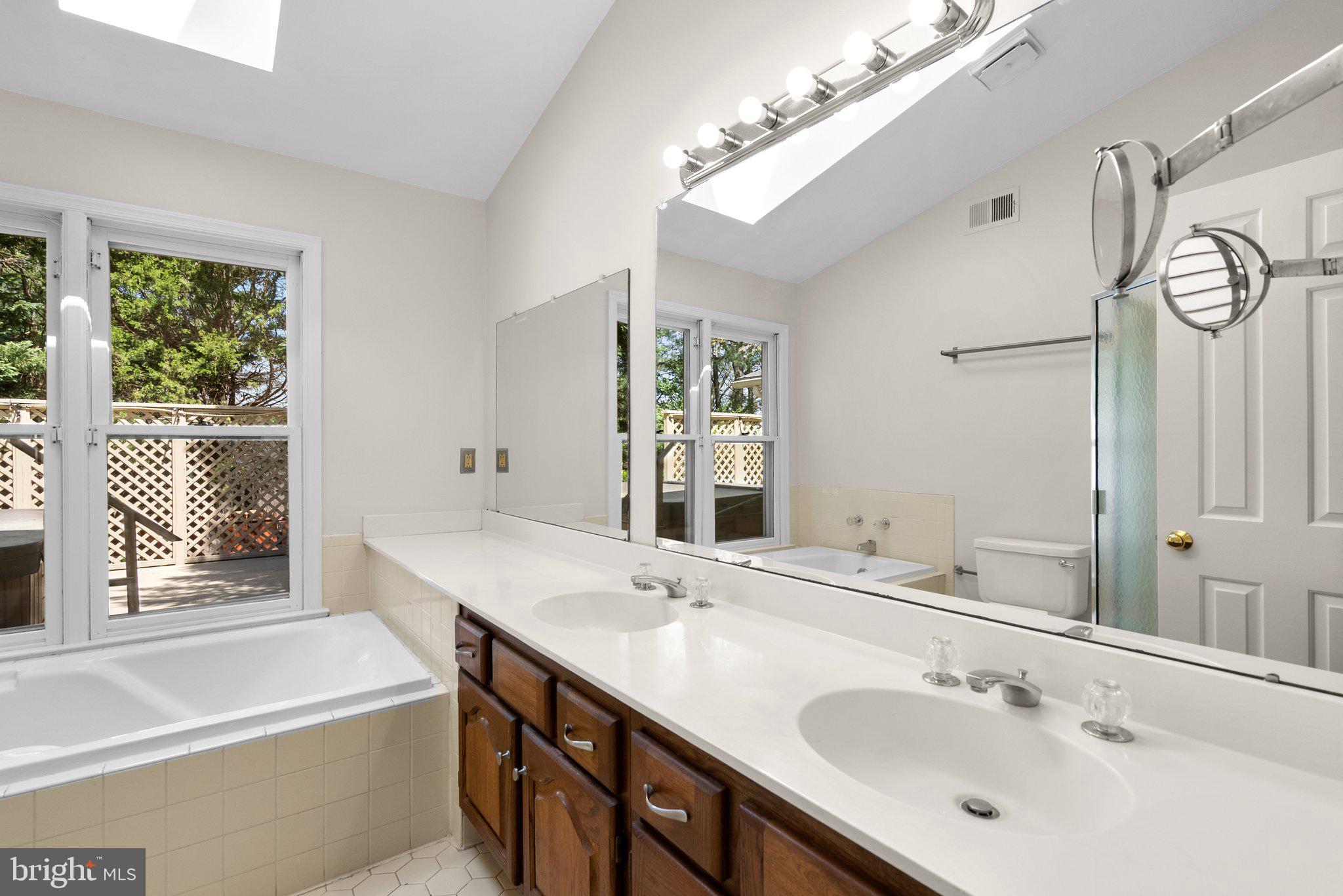 943 Willowleaf Way Potomac, MD 20854 - Photo 27 of 49 a bathroom with a tub a sink and a large mirror