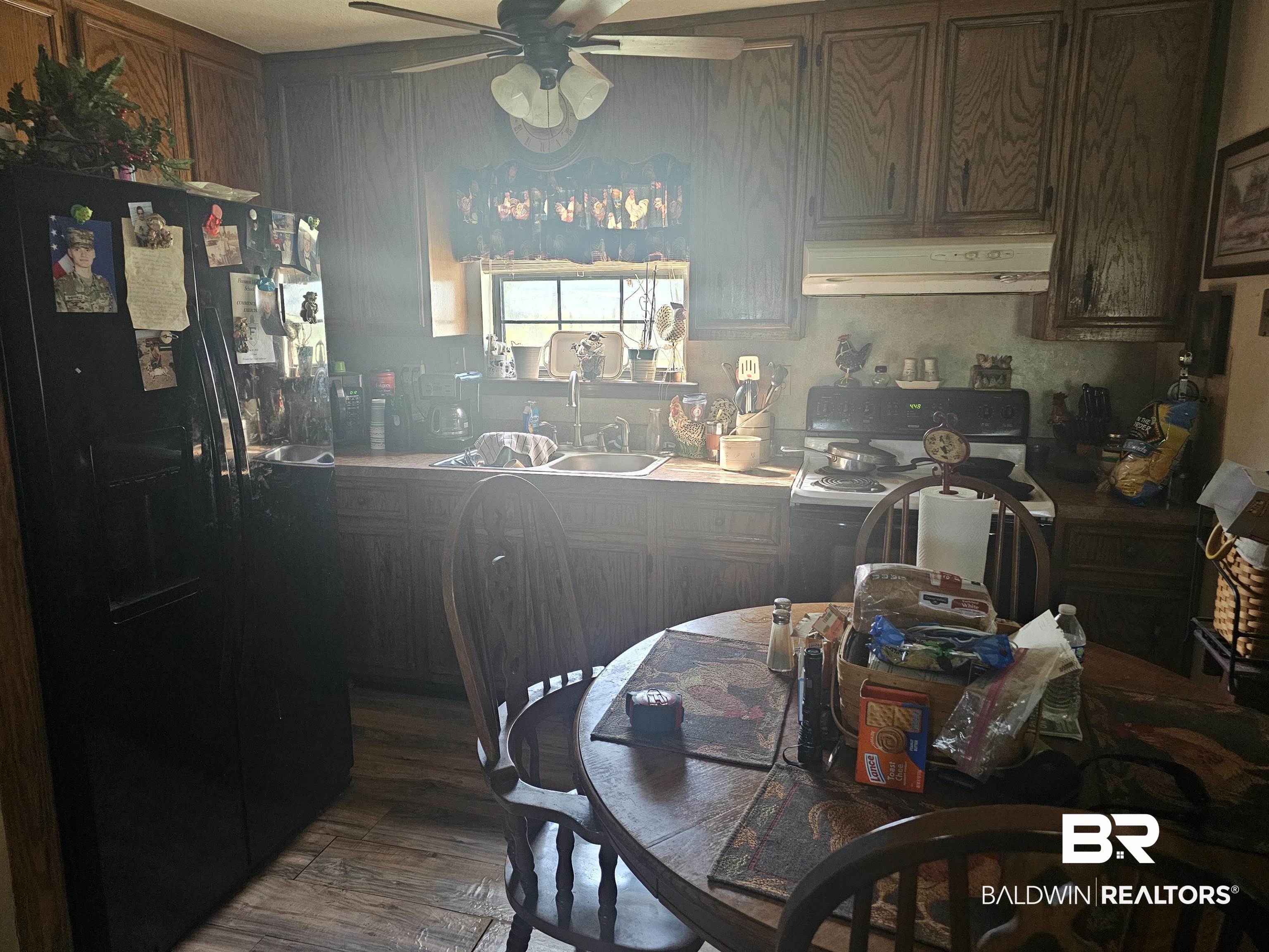 1818 Old Fannie Road Flomaton, AL 36441 - Photo 11 of 20 Kitchen with black fridge, extractor fan, range, a ceiling fan, and wood finished floors