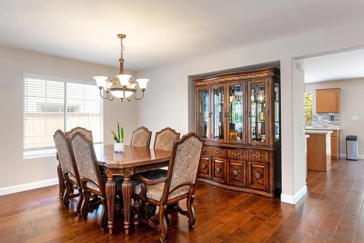 304 River Ranch Way Oceanside, CA 92057 - Photo 12 of 44 a dining room with furniture a chandelier and wooden floor
