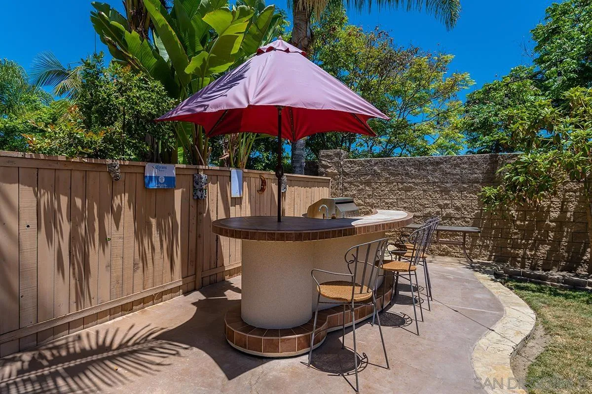 304 River Ranch Way Oceanside, CA 92057 - Photo 23 of 44 a patio with a table and chairs under an umbrella