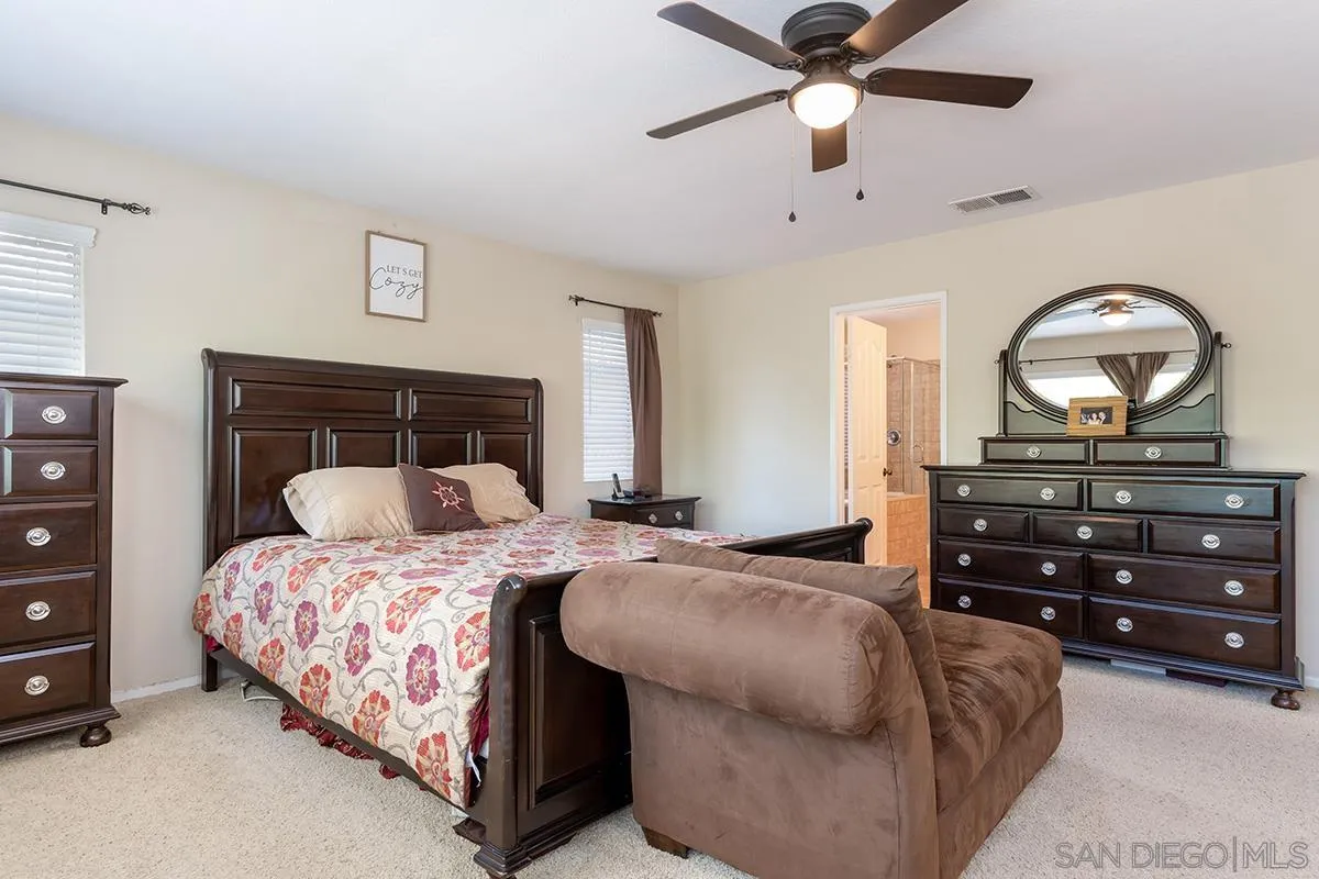 304 River Ranch Way Oceanside, CA 92057 - Photo 28 of 44 a bedroom with a bed and a chandelier