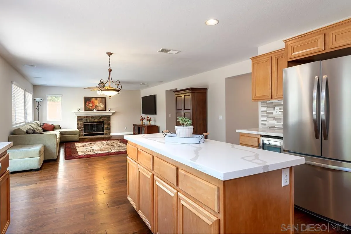 304 River Ranch Way Oceanside, CA 92057 - Photo 7 of 44 a kitchen with a refrigerator a oven a sink dishwasher and white cabinets with wooden floor