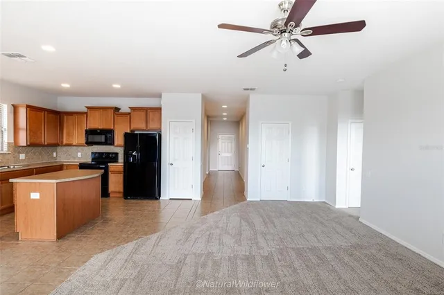 a large kitchen with stainless steel appliances kitchen island granite countertop a refrigerator a stove a sink and a microwave