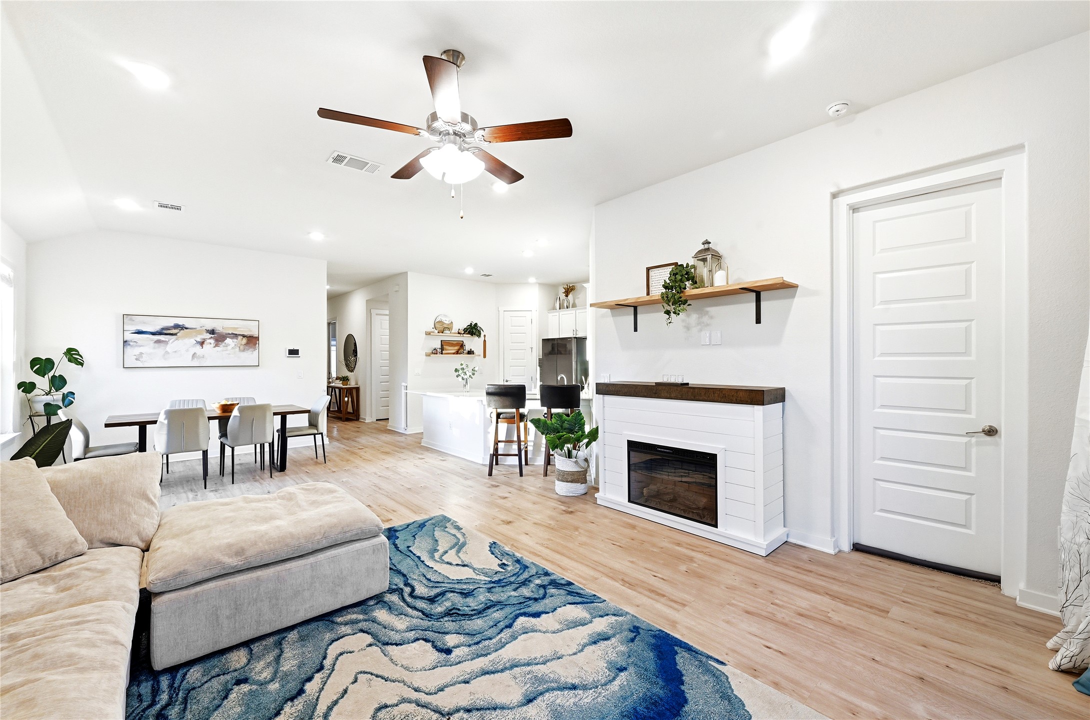 4420 Ingram Road Georgetown, TX 78628 - Photo 14 of 40 A welcoming living space features light wood flooring, an electric fireplace, and an open layout connecting to the kitchen.