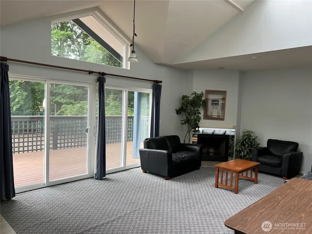 a living room with furniture a flat screen tv and a large window