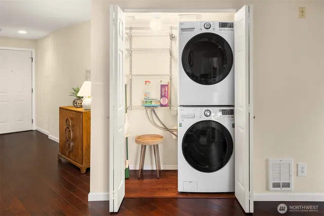 a utility room with dryer washer and wooden floor