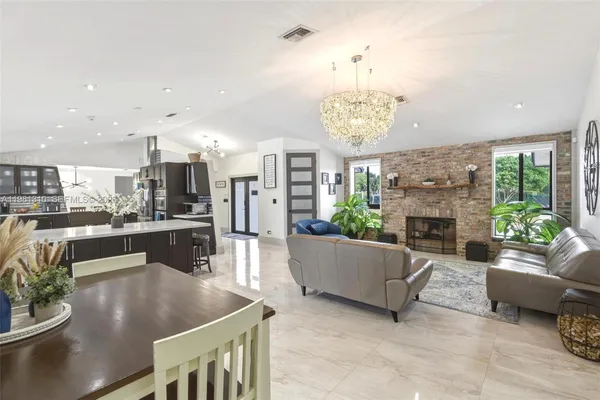 a living room with fireplace furniture and a chandelier