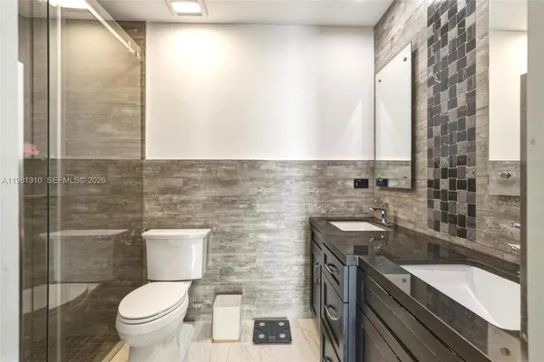 a bathroom with a granite countertop toilet a sink and a bathtub