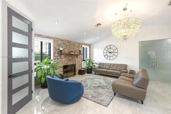 a living room with furniture a fireplace and a chandelier